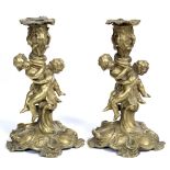 A PAIR OF 19TH CENTURY MEISSONNIERE STYLE ORMOLU CANDLESTICKS each adorned with putti, 25cm high (