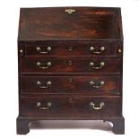 A GEORGE III HARDWOOD BUREAU the fall front with fitted interior over four long drawers and standing