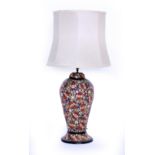 A 20TH CENTURY PAPIER MACHE BALUSTER TABLE LAMP decorated with blue, pink and red flowers and