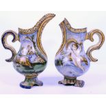 TWO ANTIQUE MAJOLICA EWERS decorated with classical scenes, each 24cm in height (AF)