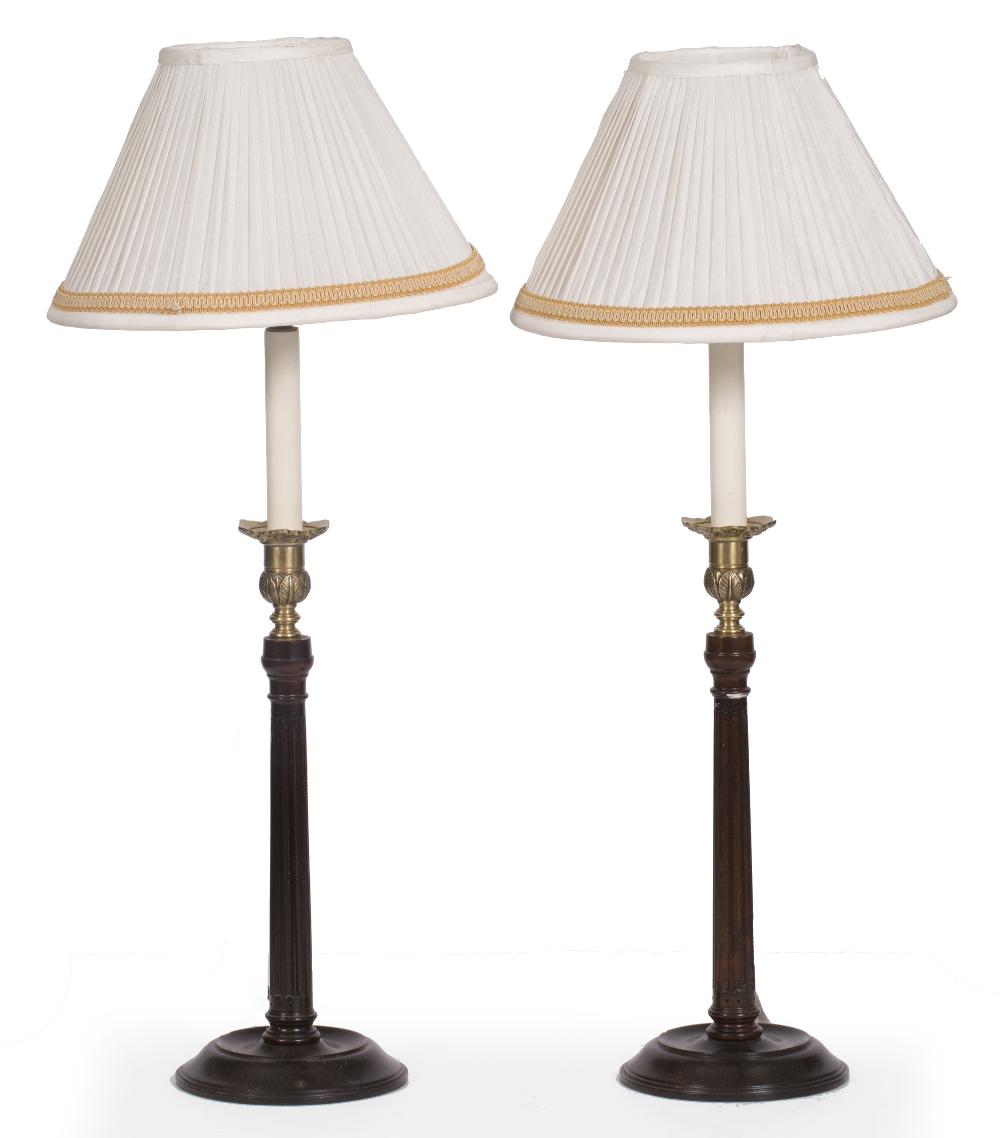 A PAIR OF GEORGIAN STYLE HARDWOOD TABLE LAMPS with fluted stems and circular spreading bases 65cm