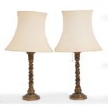 A PAIR OF CARVED PAINTED GILT WOOD AND POLYCHROME TABLE LAMPS of column form on spreading bases, the