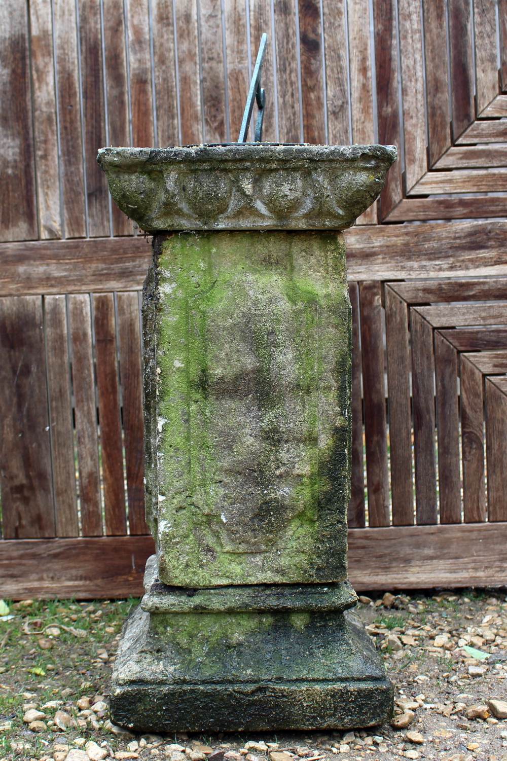 A CARVED STONE SUNDIAL of square plinth form with bronze dial plate, panelled column and on a