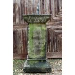 A CARVED STONE SUNDIAL of square plinth form with bronze dial plate, panelled column and on a