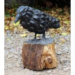 A SCULPTURE of a crow on a wooden perch, moulded with mussel shells 39cm wide x 36cm high overall