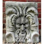 A CAST RECONSTITUTED STONE WALL PLAQUE depicting a wild man type mask, 43cm wide x 58cm high