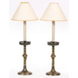 A PAIR OF VICTORIAN BRASS GOTHIC REVIVAL CANDLESTICKS with painted flowerhead and line decoration,