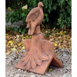 A TERRACOTTA ROOF RIDGE TILE FINIAL in the form of a dove looking outwards, 29cm long x 48cm high
