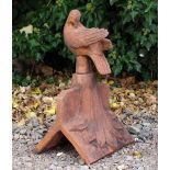 A TERRACOTTA ROOF RIDGE TILE FINIAL decorated with a dove preening its feathers, 30cm wide x 47cm