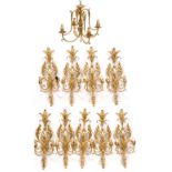 NINE CONTEMPORARY GILDED WALL LIGHTS with scrolling acanthus leaves and faux wax fittings 64cm