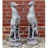 A PAIR OF RECONSTITUTED STONE SCULPTURES depicting seated whippets, each on an octagonal plinth