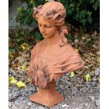 A CAST TERRACOTTA BUST OF AN ART NOUVEAU GIRL with flowers in her hair and on a square plinth