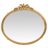 A VICTORIAN GILT OVAL WALL MIRROR with floral crest, 134cm wide x 124cm high