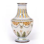 A CONTINENTAL FAIENCE TIN GLAZED VASE of baluster form decorated in ochres, blues and greens 13cm