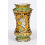 A 17TH CENTURY ITALIAN TIN GLAZED DRUG JAR decorated with a cupid figure and armorial trophies,