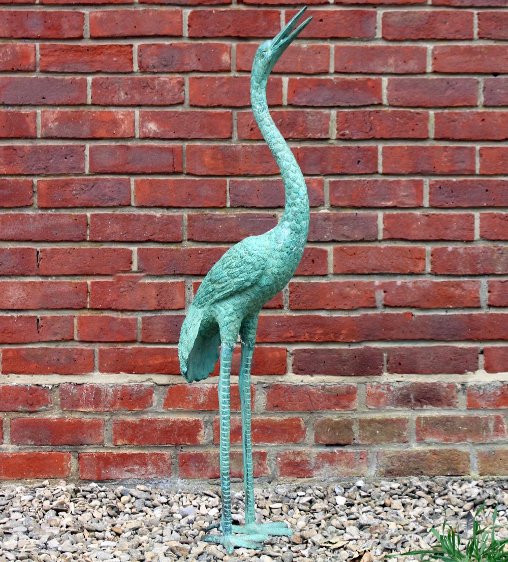 A GREEN PAINTED BRONZE GARDEN FOUNTAIN in the form of a standing stork, 107.5cm high