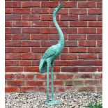 A GREEN PAINTED BRONZE GARDEN FOUNTAIN in the form of a standing stork, 107.5cm high