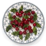 CHRISTINE VIENNET - A TROMPE L'OEIL PAINTED CERAMIC AND GLAZED PLATE OF CHERRIES signed beneath,