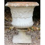 AN OLD WHITE PAINTED TERRACOTTA URN of classical form decorated with a band of scrolling acanthus