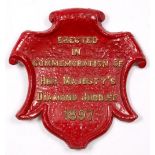 A VICTORIAN SMALL RED PAINTED PARCEL GILT CAST IRON COMMEMORATIVE SHIELD making reference to Queen