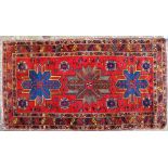 A RED GROUND RUG with three star motifs to the central field and within a triple banded border,