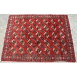 A MODERN RED GROUND RUG with thirty five geometric designs to the central field and within a