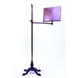 A VICTORIAN ADJUSTABLE READING STAND with a brass column and a cast iron base