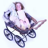 A GERMAN ARMAND MARSEILLE BISQUE HEADED DOLL further doll parts and a wicker doll's pram