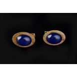 A PAIR OF CABOUCHON SET CUFFLINKS Each oval textured panel centred with a cabouchon blue stone, on
