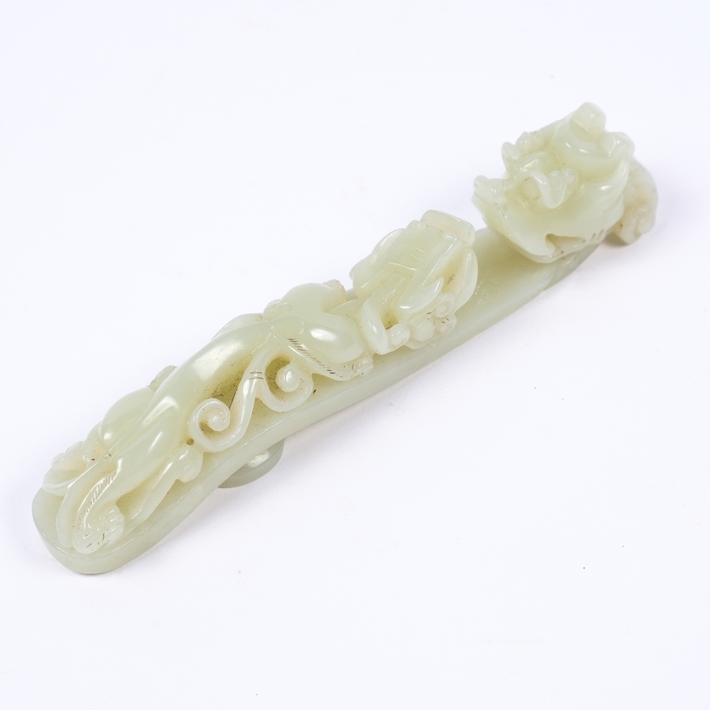 A Chinese white jade belt buck 19th Century with dragon headed hook and a sinuous pierced and carved - Image 2 of 2