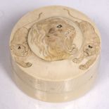 A Japanese ivory circular box and cover Meiji period carved and engraved with lions, 7cm diameter