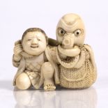 A Japanese ivory netsuke of a youth late Meiji seated beside a fisherman's basket upon which an