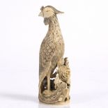 A Chinese ivory carving of a phoenix early 20th Century perched upon a rock around which grows a