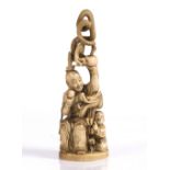 A Japanese ivory okimono of a Handaka Sonja late Meiji seated upon a stool while holding aloft a