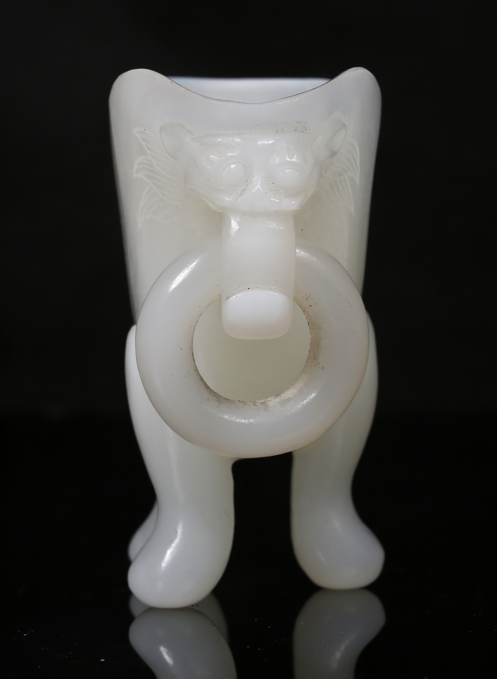 A Beijing opaline white glass libation cup 19th Century the flattened body on tripod feet with