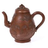 A Chinese Yixing teapot 19th Century having raised peonies, 14cm high