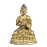 A Tibetan gilt bronze figure of a seated Buddha 19th Century on lotus throne, hands in mudra, 15cm