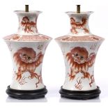 A pair of Chinese white ground vases each painted in iron red with Dogs of Fo converted to table