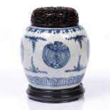 A Chinese blue and white jar 18th century with stylised bat designs, with pierced hardwood cover and