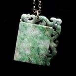 A Chinese jade pendant the rectangular panel with scroll carved border on a belcher-link chain