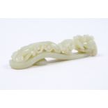 A Chinese white jade belt buck 19th Century with dragon headed hook and a sinuous pierced and carved