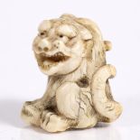 A Japanese ivory netsuke of a seated tiger Meiji period 4cm high