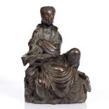 A Chinese bronze Shih-sou figure of Quanyin 18th/19th Century the seated upon a gnarled rock