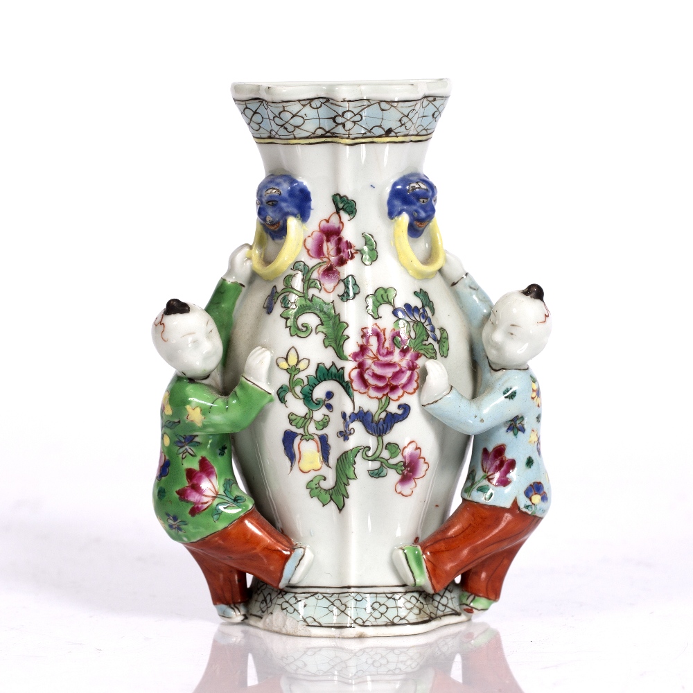 A Chinese famille rose wall pocket 18th Century depicting two boys set against a fluted vase, 17cm