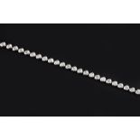 A DIAMOND LINE BRACELET, comprising an articulated line of collet set round brilliant-cut