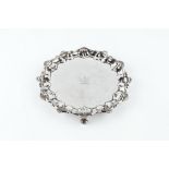 A LATE VICTORIAN SILVER WAITER, with scallop and scroll cast piecrust border, on scroll feet by