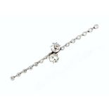 A DIAMOND TWO STONE BAR BROOCH, of crossover design, obliquely claw set with two principal cushion-