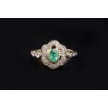AN EMERALD AND DIAMOND PANEL RING, the oval mixed-cut emerald collet set within an openwork