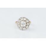 A DIAMOND CLUSTER RING, the principal cushion-shaped old-cut diamond in claw setting, within a