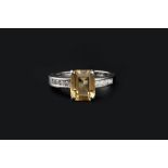 A CITRINE AND DIAMOND DRESS RING, the rectangular step-cut citrine in four-claw setting, between